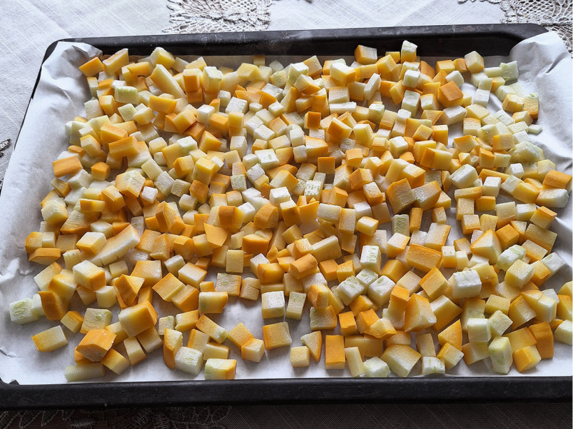Kabačus sagriež kubiņos un vienā kārtā izber uz paplātes, kurā ieklāts cepampapīrs.