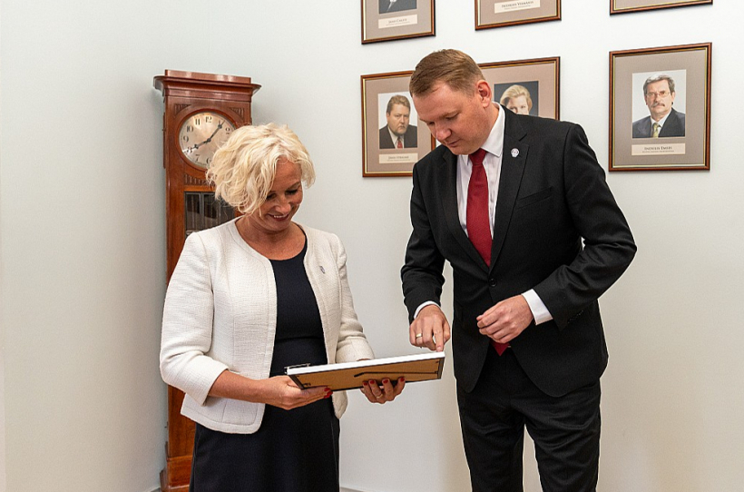 Jaunā Daiga Mieriņa un iepriekšējais Saeimas priekšsēdētājs Edvards Smiltēns pie Saeimas spīkeru portretu galerijas.