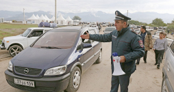 Armēņu policists regulē bēgļu ierašanos Kornidzorā, kas ir Armēnijas un Kalnu Karabahas robežciems. Tur viena pēc otras ierodas ļaužu un mantu pilnas automašīnas.