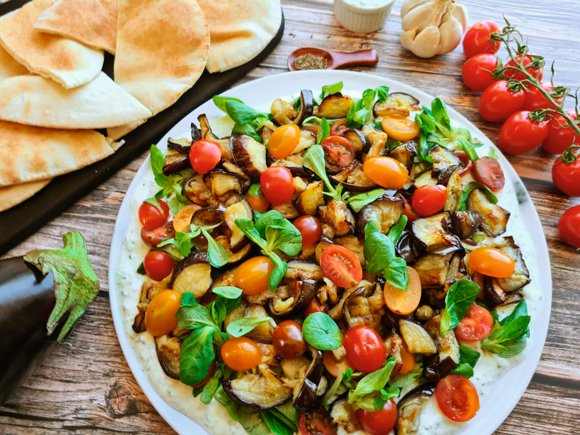 Ceptu baklažānu salāti ar gurķu–jogurta mērci.