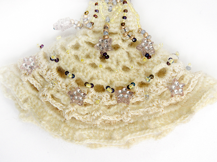 Šo bruncīti veido pēc aplīša tamborēšanas principa. To papildus izšuj ar pērlītēm.