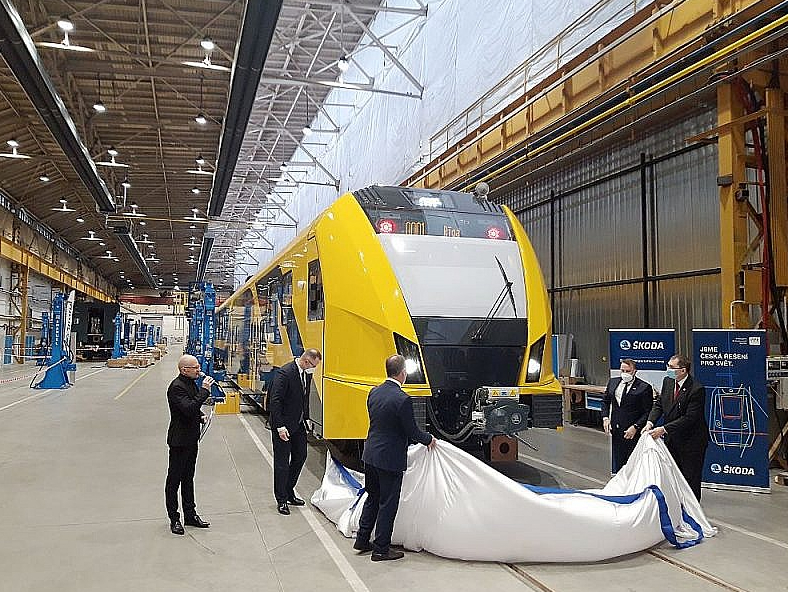 Pirmā Latvijai saražotā elektrovilciena svinīgā atklāšana koncerna "Škoda Vagonka" rūpnīcā Ostravā (Čehija) 2022. gada 23. februārī (piedalās arī "Pasažieru vilciena" vadītājs Rodžers Jānis Grigulis un tā laika satiksmes ministrs Tālis Linkaits). Nākamajā dienā visa pasaule uzzināja, ka Krievija iebrukusi Ukrainā. Karš Eiropā ietekmēja arī saražoto vilcienu nonākšanu līdz Latvijas pasažieriem – pirmais brauciens notiek vismaz ar gada kavēšanos.