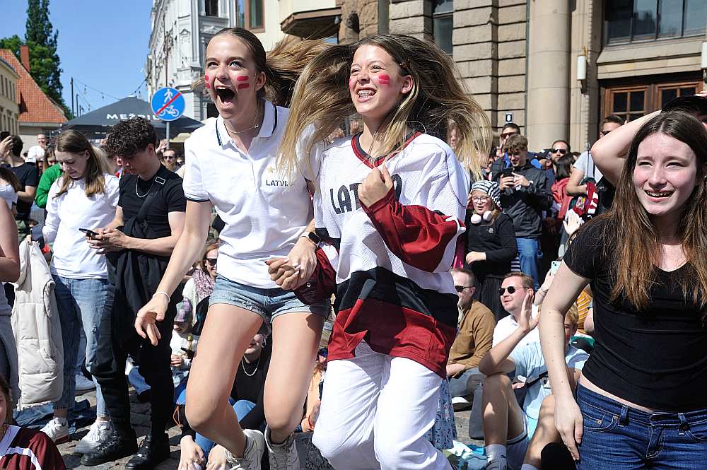 Hokeja fani Rīgā Doma laukumā vēro Latvijas izlases spēles translāciju.