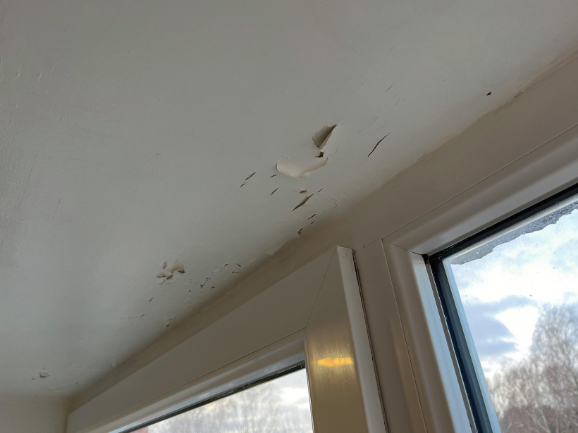 Mitruma bojājumi loga ailā, kurā ielikts pakešu logs. Gaisa apmaiņa nenotiek, rezultātā krāsa nolobās no rīģipša apdares.