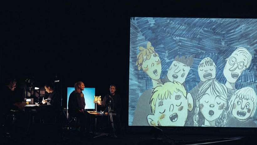 Līdzās aktieriem uz skatuves atrodas milzu ekrāns, uz kura dzīvās animācijas tehnikā darbojas aktieru roku kustināti tēli.